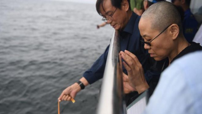 妻の劉霞さん(右)が祈るなか、劉暁波氏の遺骨は大連近くの海に散骨された