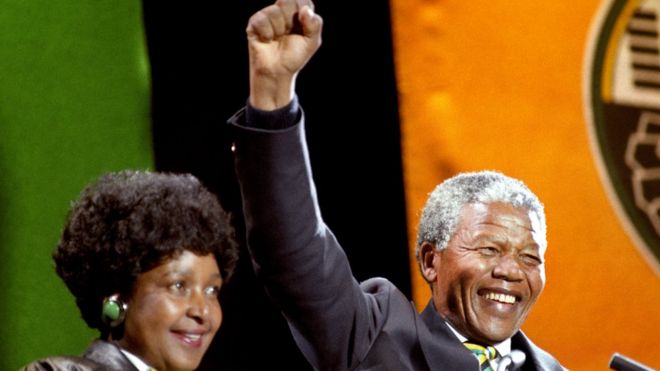 Nelson Mandela, with his then-wife Winnie, gives the famous clench-fist salute of the African National Congress to tens of thousands of fans who gathered to hear him at a concert in his honour at Wembley Stadium on 17 April 1990