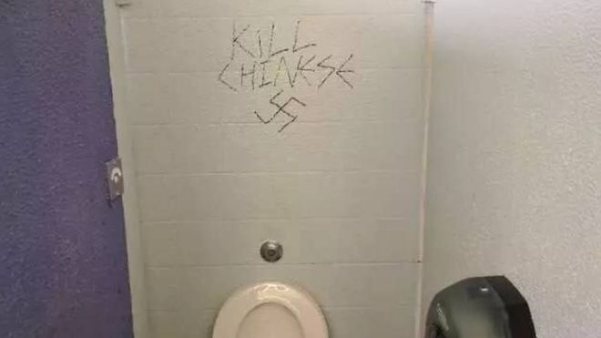 Graffiti on a wall says "kill Chinese" alongside a swastika