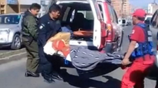 La víctima es retirada en camilla y colocada en una ambulancia.