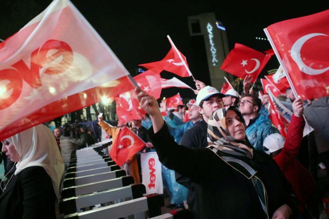 Supporters of Turkey's president celebrate as they wave Turkish national flags during a rally near the headquarters of the ruling AP in Ankara, 16 April