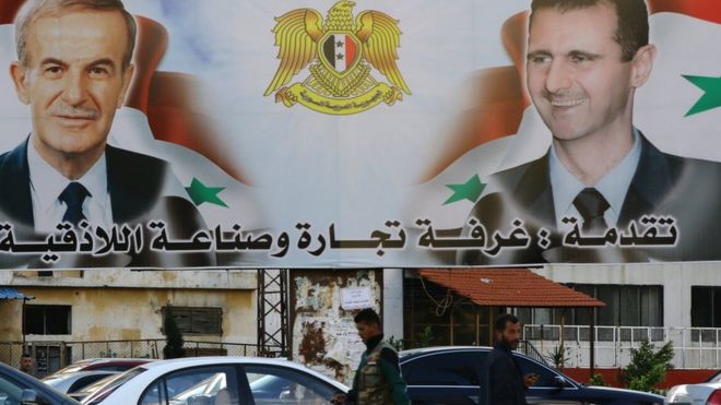 A billboard sponsored by the chamber of commerce and industry shows pictures of Syrian President Bashar al-Assad (R) and his late father former president Hafez al-Assad in the coastal city of Latakia (17 March 2016)