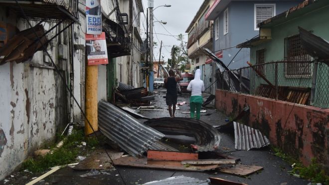 Men survey the damage caused by Hurricane Maria in San Juan, Puerto Rico.