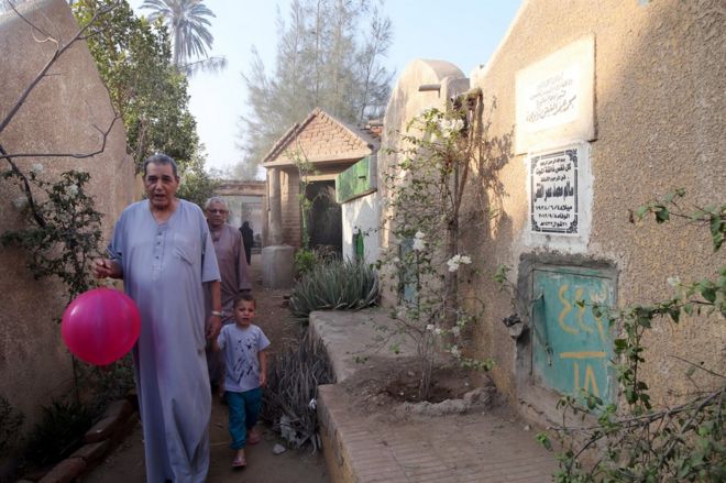 People visit a cemetery during the Muslim holiday of Eid al-Fitr, in the village of Dalgamon, Tanta, some 120km north of Cairo, Egypt, 25 June