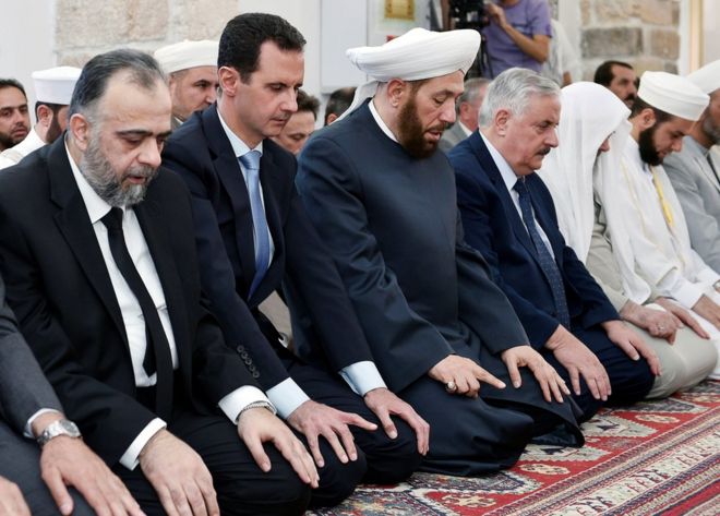 Syrian President Bashar al-Assad (2nd L) attends prayers in Hama, 25 June