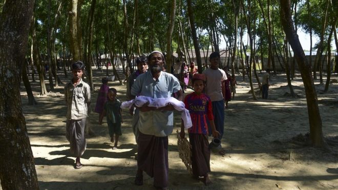 A Myanmar Rohingya refugee carries the body of six-month-old Alam for his burial in a refugee camp in Teknaf, in Bangladesh's Cox's Bazar district, on November 26, 2016.