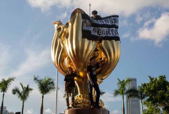 Members of political parties Demosisto, the League of Social Democrats and People Power stand on the six-meter-high Golden Bauhinia statue during a protest in Golden Bauhinia Square in Hong Kong, China, 28 June 2017