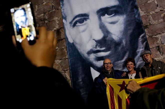 Tres personas posan sosteniendo una estelada (bandera independentista catalana) frente a un retrato de quien fuera presidente de la Generalitat, Lluís Companys, el 15 de octubre de 2016.