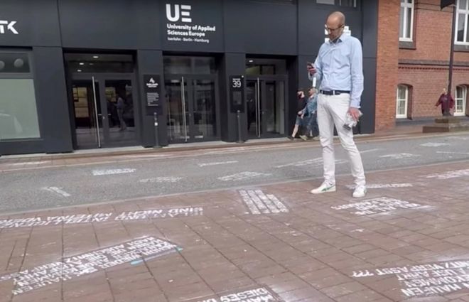 A man takes pictures of "hate tweets", a part of the art project "#HEYTWITTER" created by Shahak Shapira, outside Twitter office in Hamburg, Germany August 4, 2017