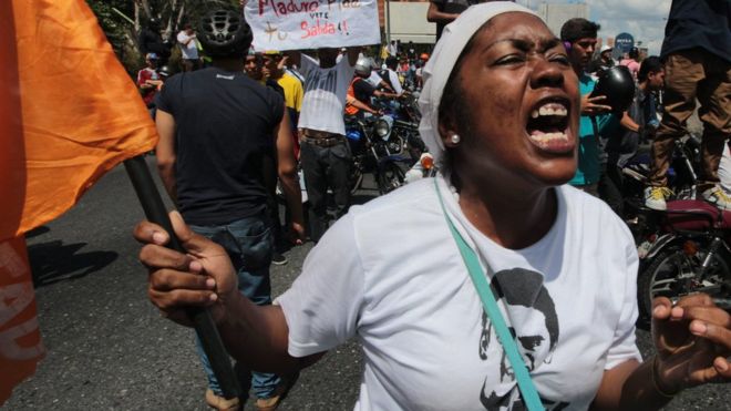 Una mujer protesta con una bandera