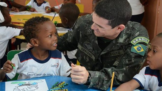 Militar brasileiro com menino haitiano