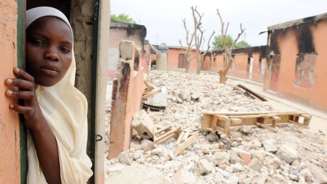 A female student stands in a burnt classroom at a school in Maiduguri, Nigeria, on 12 May 2012