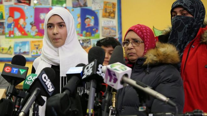 Khawlah Noman, 11, speaks to reporters with her mother