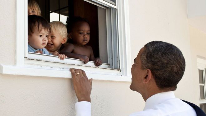 El expresidente de EE.UU., Barack Obama, sonríe a un grupo de niños en una guardería.