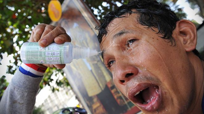 Un hombre trata de aliviar el efecto del gas lacrimógeno sobre sus ojos durante una manifestación antigubernamental en Bangkok, Tailandia, BANGKOK, en 2013.