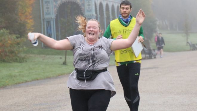 Dawn Nisbet crossing the finish line with her hands in the air and a big smile on her face