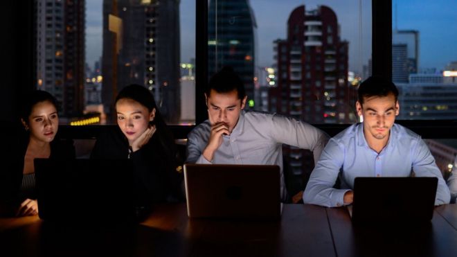 Hombres y mujeres trabajando en un turno noche.