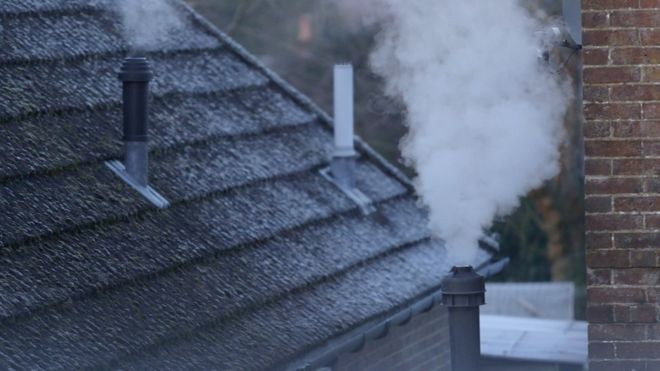 Smoke rising from chimney's on a cold day
