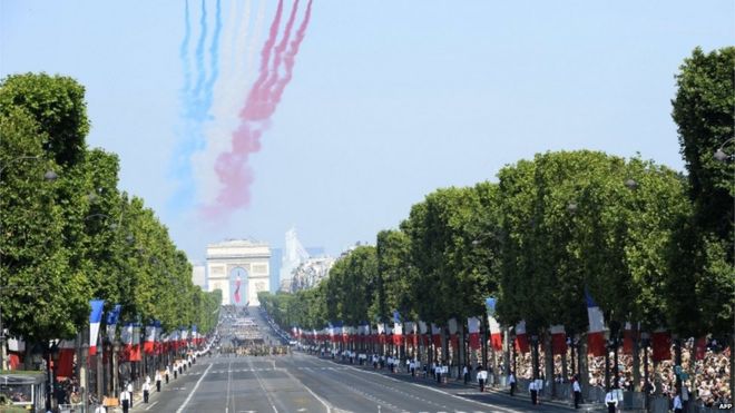 Nine planes from the French Air Force Patrouille de France release trails of red, white and blue smoke, the colours of French national flag as they take part in a fly over during the Bastille Day parade on the Champs-Elysees avenue, 2013