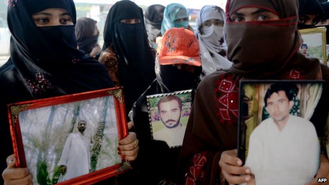 Pakistani Baloch women carry photographs of missing ethnic Balochs at Hub district as they march towards Karachi from Quetta, the capital of Baluchistan Province on 21 November 2013