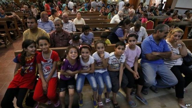 Iraqi Christians who fled the violence in the village of Qaraqush, about 30 kilometres east of the northern province of Nineveh, sit in Saint-Joseph church in the Kurdish city of Erbil