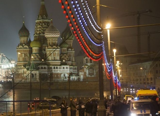 Police stand around the body of Boris Nemtsov in Moscow, with St Basil's Cathedral and the Kremlin in the background, 27 February