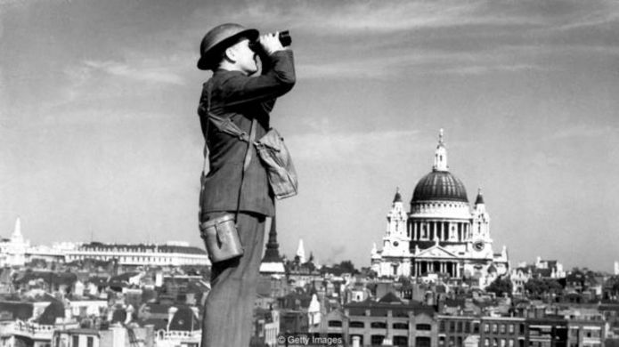 Một người lính phòng không theo dõi bầu trời London trong thời Đức ném bom, khi đó tòa thánh St Paul vượt cao trên hết mọi công trình ở thành phố.