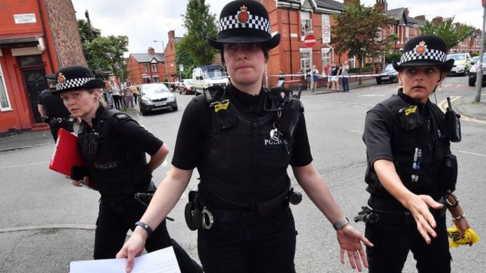 Police put up a corden as they attend the scene of a raid in the Moss Side area of Manchester