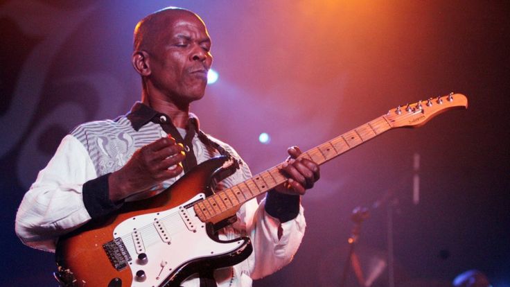 Ray Phiri performs on stage with his guitar