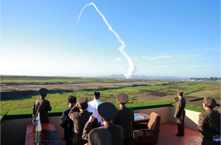 This undated picture released from North Korea's official Korean Central News Agency (KCNA) on 28 May 2017 shows North Korean leader Kim Jong-un (in white shirt) watching the test of a new anti-aircraft guided weapon system organized by the Academy of National Defence Science at an undisclosed location.
