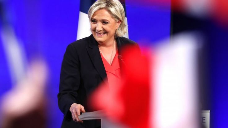 Marine Le Pen delivers a speech on stage after losing the French presidential run-off
