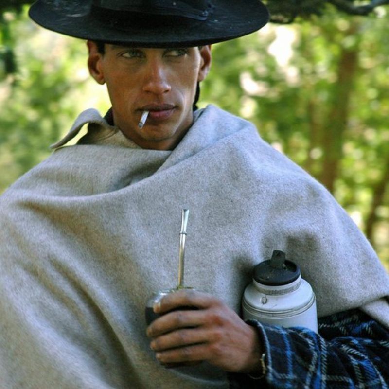 Gaucho fumando y tomando mate.