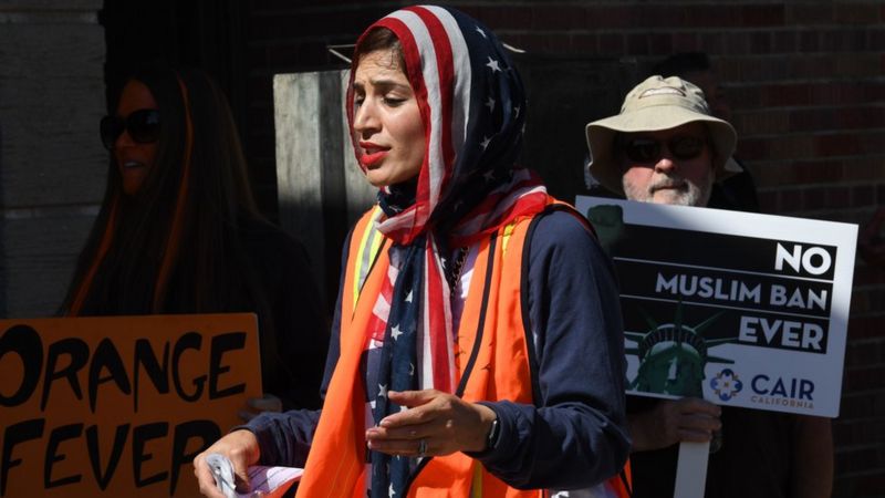 A woman wears an American flag for a headscarf as she participates in the "#NoMuslimBanEver" rally in downtown Los Angeles, California on October 15, 2017