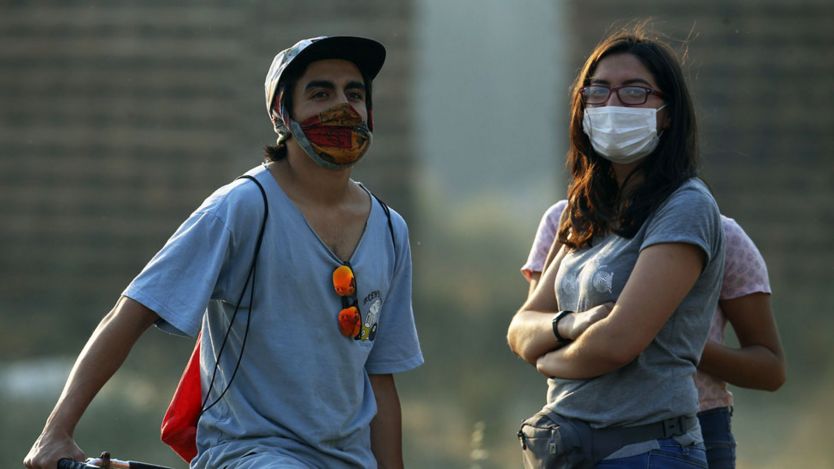 Un joven y una joven con máscaras para protegerse del humo