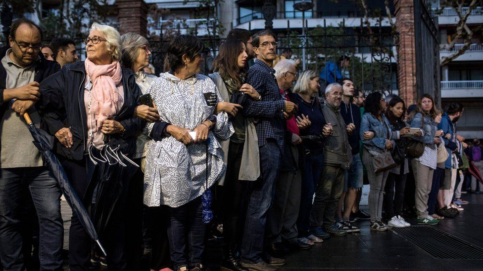 People join arms as they clear a path for the arrival of the official ballot boxes to arrive at the Escola Industrial of Barcelona school polling station on October 1, 2017 in Barcelona, Spain.