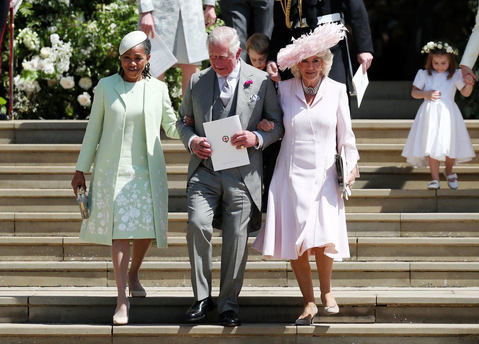 Doria Ragland, mother of the bride, the Prince of Wales and the Duchess of Cornwall walk down the steps of St George's Chapel in Windsor Castle after the wedding of Prince Harry and Meghan Markle