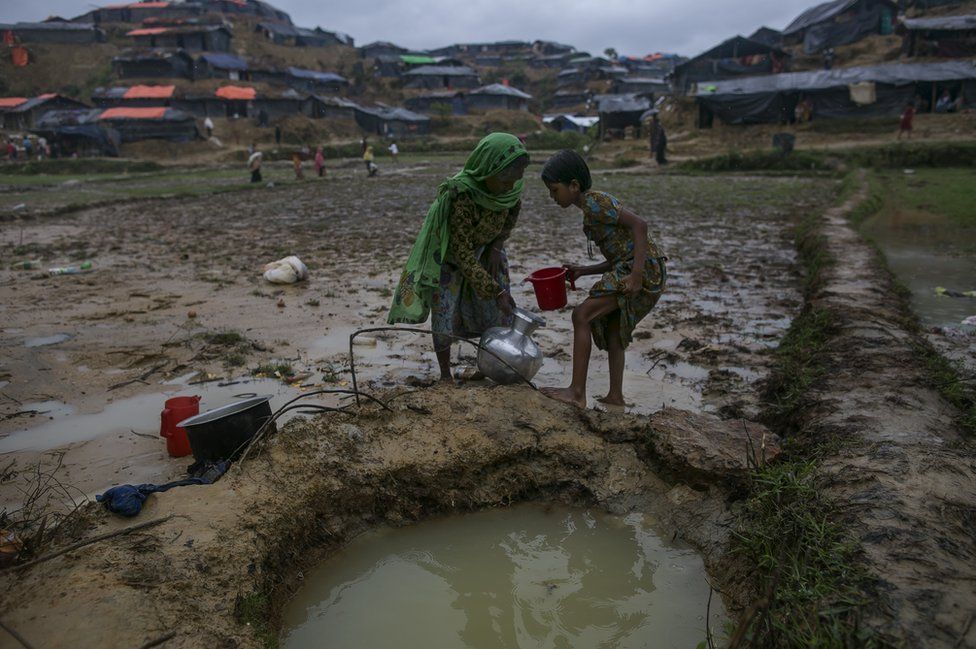 Women collect water from a hole that surrounding households use for washing, drinking, cooking and bathing in the Balukhali camp in Cox's Bazar, Bangladesh, 18 September 2017.