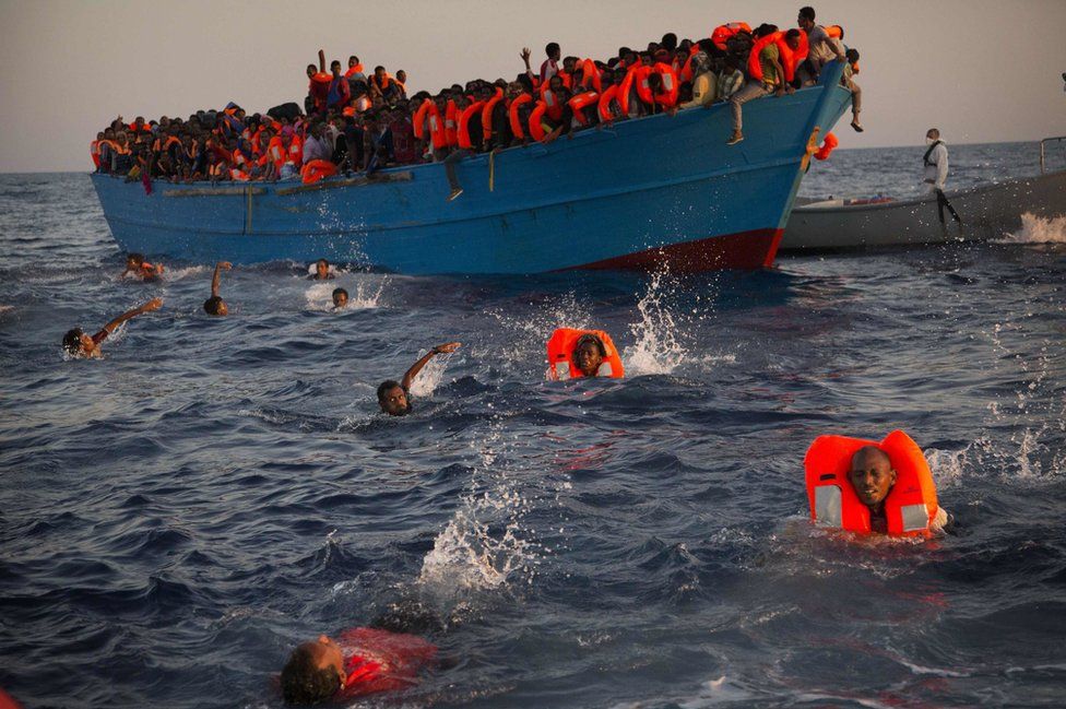 Migrants, most from Eritrea, jump into the water from a crowded wooden boat as they are helped by members of an NGO during a rescue operation in the Mediterranean sea, about 13 miles north of Sabratha, Libya, on 29 August 2016.