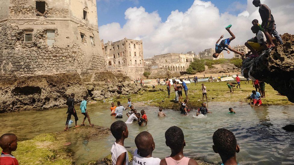 Somali children dive, play and swim in front of the ruins of an old building on the coastal district of Hamarweyne, in Mogadishu on Friday.