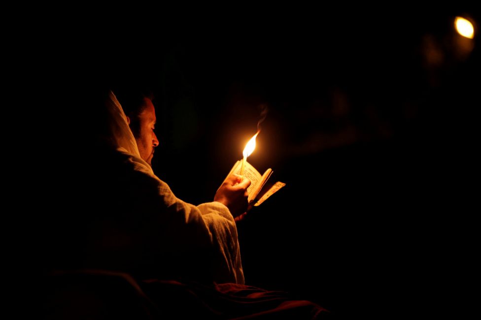 An Ethiopian Orthodox pilgrim reads the Bible during the Christmas Eve celebration in Bete Mariam (House of Mary) monolithic Orthodox church in Lalibela, Ethiopia January 7, 2018.