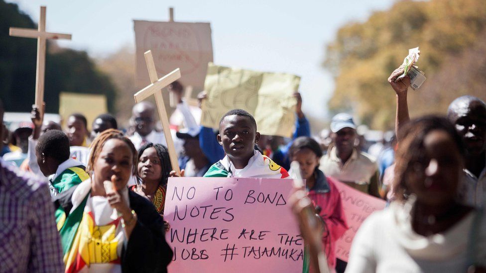 Protesters in Harare, Zimbabwe, holding crosses and one holding a sign reading "No to bond notes, where are the jobs" - Wednesday 3 August 2016