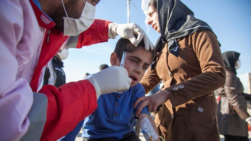 Un socorrista atiende en medio de la calle a un niño herido por el terremoto