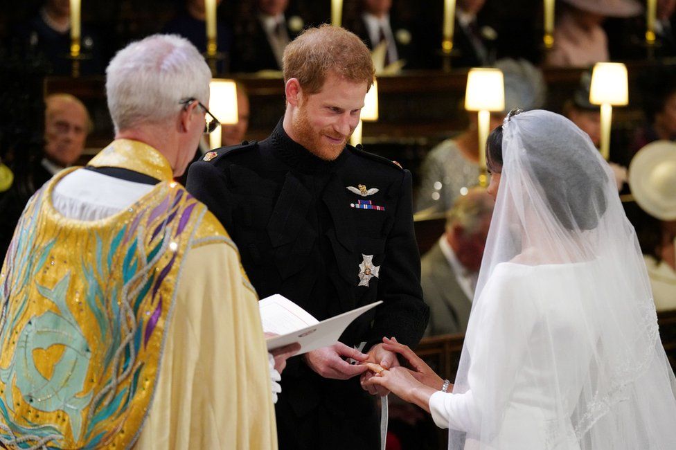 Prince Harry places the wedding ring on the finger of Meghan Markle in St George"s Chapel