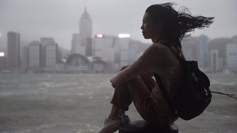 香港尖沙咀海傍一名女士冒着台风观赏维多利亚港（23/8/2017）