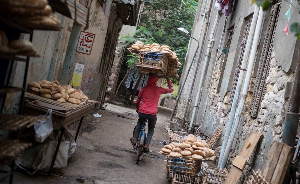 An Egyptian man carries a wood rack full of bread near a traditional bakery in Al Sayeda Zainab district, Cairo, Egypt, 22 November 2017