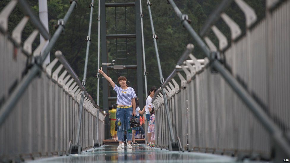 Turista sobre plataforma suspendida sobre un acantilado
