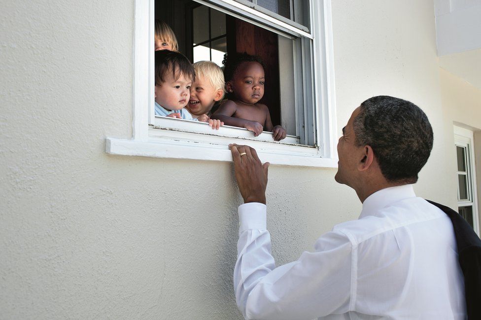 Obama looks through a window