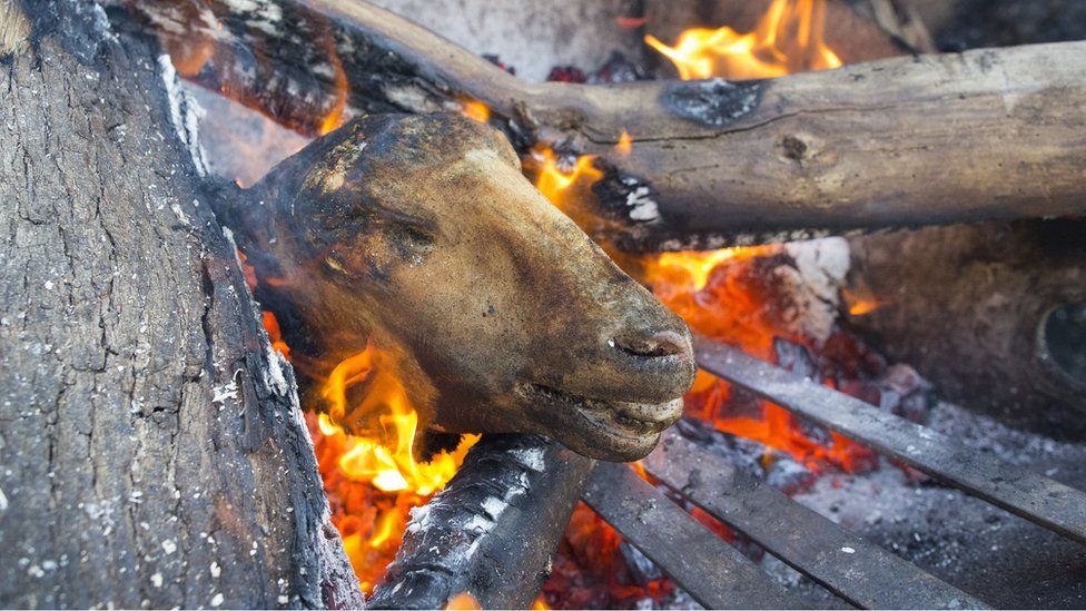 A sheeps head known locally as a "Smiley" is prepared in a fire at a butchery in Masiphumelele, Cape Town, South Africa, 04 May 2017. Meat cooked on an open wood fire is known as braaing in South Africa and is very popular amongst township residents. This butcher shop has been running for the past five years. Slaughtered Cows and Sheep are sourced from a farm in Paarl some 120 kilometers A butcher displays cuts of meat for sale at a butchery in Masiphumelele, Cape Town, South Africa, 04 May 2017. Meat cooked on an open wood fire is known as braaing in South Africa and is very popular amongst township residents. This butcher shop has been running for the past five years.