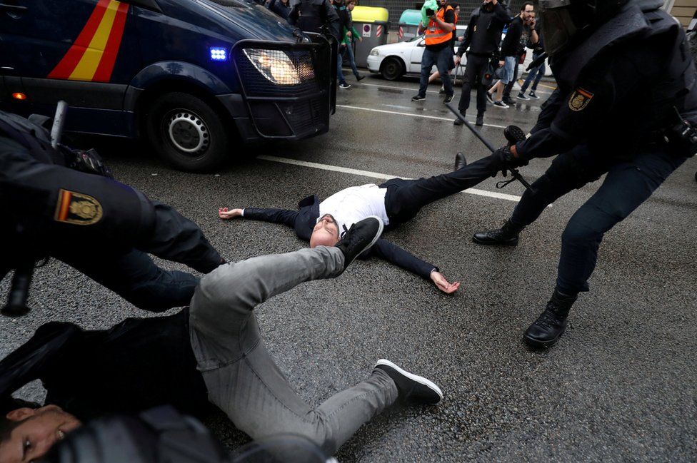 Oficiales de la Guardia Civil española retiran a manifestantes frente a un colegio electoral en Barcelona el día que se celebró un referéndum de independencia.