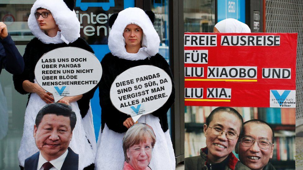Protesters dressed as pandas with a big picture of Liu Xiaobo and Liu Xia, and slogans in German